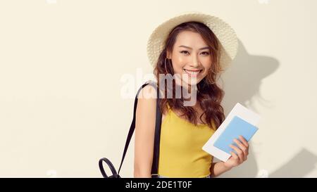 Asiatische Frau tragen Strohhut in der Hand halten Passbuch. Frau bereit, mit Pass auf weißem Hintergrund zu reisen. Stockfoto