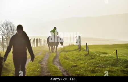 Brighton UK 28. November 2020 - EIN Reiter genießt einen schönen Morgen auf der Brighton Racecourse, wenn die Sonne beginnt, aus dem frühen Nebel zu brennen. : Credit Simon Dack / Alamy Live News Stockfoto