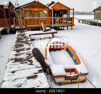 Winterzeit auf dem Angelsee. Schwimmendes Dorf.gefrorener See, gefrorenes Boot, gefrorene Zeit. Stockfoto