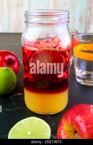 Lebendige Farbe der hausgemachten Rotwein Sangria in einem Gras Flasche vor dem Mischen Stockfoto
