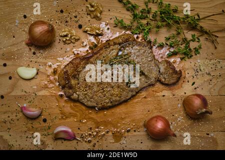 Frisch gebratenes, mittelseltenes Sirloin-Steak, das mit Saft aufgoost Das Schneidebrett Stockfoto