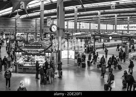 Die Leute laufen auf der Bahnhofsbahn am Münchner Hauptbahnhof Stockfoto