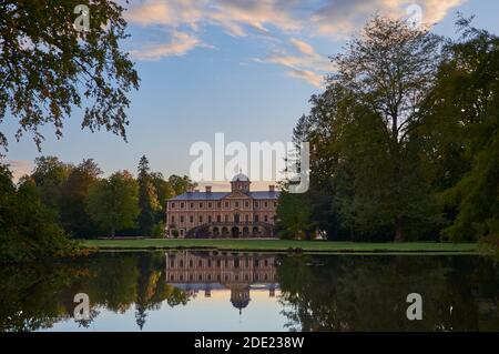 Rastatt Favorite Palace und idyllischer Palastgarten mit Bäumen spiegeln Im Teich bei Sonnenuntergang Stockfoto