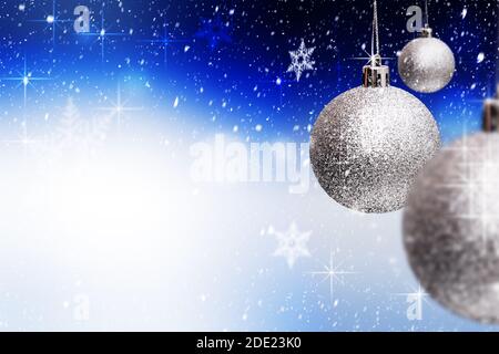 Drei Glas Silber Weihnachtsschmuck hängen über schneeweißen blauen Hintergrund mit Schneeflocken, funkelt. Frohe Weihnachten und ein glückliches neues Jahr Grußkarte Stockfoto