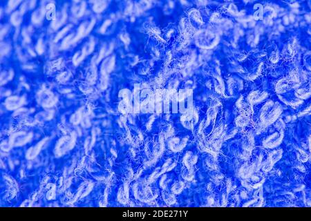 Defokussierte flauschige Wolltextur auf unscharfen Hintergrund, abstrakter blauer Hintergrund. Unscharfe Strickstruktur, flacher dof. Stockfoto