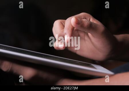 Man Hand mit digitalen Tablet auf schwarzem Hintergrund Stockfoto