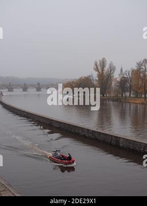 Polizeiboot auf der Moldau vor der Karlsbrücke An einem nebligen Herbstmorgen Stockfoto