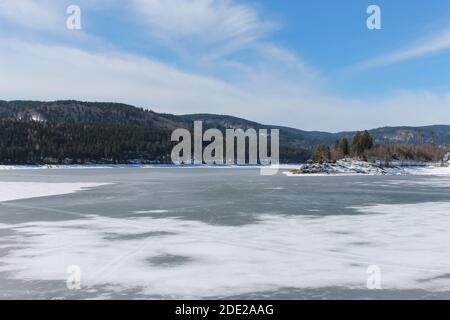 Gefrorener See in Winterlandschaft.Bergwaldsee mit Eis und Schnee Hintergrund.Schluchsee in Schwarzwald, Deutschland Stockfoto