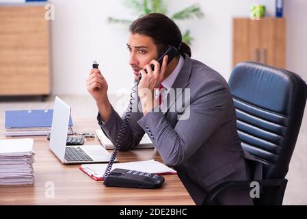 Männlicher Mitarbeiter, der Flash-Laufwerk in den Laptop einsteckt Stockfoto