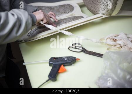 Arbeiter macht Möbel Restaurierung mit Heißklebepistole und Klebeband Stockfoto