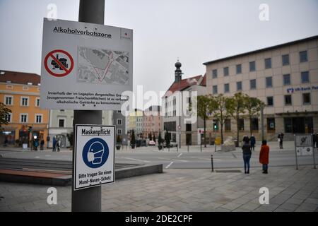 Passau, Deutschland. November 2020. Schilder am Ludwigsplatz weisen auf die bestehende Alkoholverbotszone und die Zwangsmasken in Passau hin. Angesichts des starken Anstiegs der Coronainfektionen sind in Passau seit Samstag strenge Ausreisebeschränkungen in Kraft.Quelle: Lino Mirgeler/dpa/Alamy Live News Stockfoto