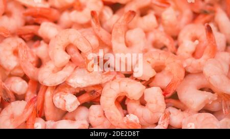 Gefrorene geschälte Garnelen sind im Supermarkt in großen Mengen. Verkauf von Meeresprodukten. Stockfoto