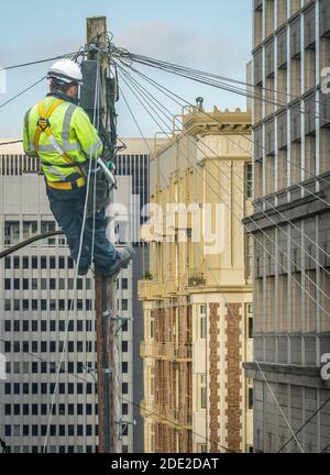 Linienarbeiter (oder Linienarbeiter oder Ingenieur) in EINER Stadt (San Francisco) Reparieren EINER Telefonleitung Stockfoto