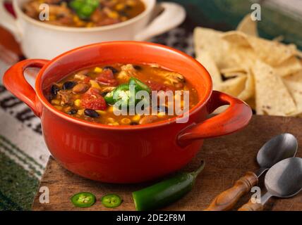 Leckere Schüssel mit würziger Chicken Taco Suppe in einer Orange Schüssel mit Tortilla Chips Stockfoto