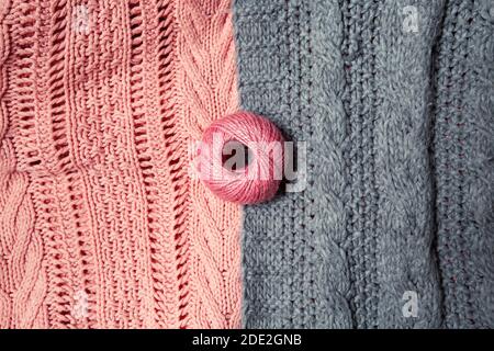 Ball aus rosa Wolle auf grau und rosa Strickpullover Stockfoto