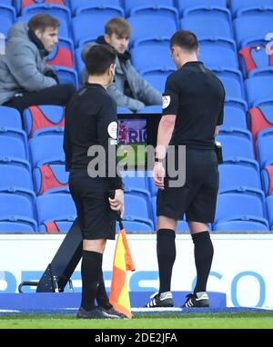 Schiedsrichter Stuart Attwell konsultiert VAR, bevor er Brighton und Hove Albion während des Premier League-Spiels im AMEX Stadium in Brighton eine Strafe für ein Foul von Liverpools Andrew Robertson gegen Danny Welbeck überlässt. Stockfoto