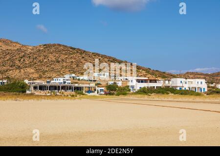 IOS Insel, Griechenland - 21. September 2020: Blick auf den beliebten Manganari Strand mit weißen Villen und Restaurant. Berg im Hintergrund. Stockfoto