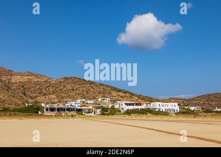 IOS Insel, Griechenland - 21. September 2020: Blick auf den beliebten Manganari Strand mit weißen Villen und Restaurant. Berg im Hintergrund. Stockfoto