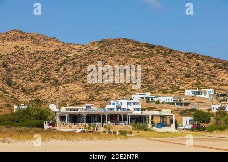 IOS Insel, Griechenland - 21. September 2020: Blick auf den beliebten Manganari Strand mit weißen Villen und Restaurant. Berg im Hintergrund. Stockfoto