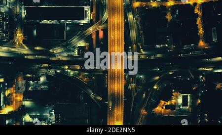 Top down Nacht Stadtverkehr Autobahn an Laternen mit Beleuchtung Stadtbild Luftbild. Downtown Outdoor-Landschaft mit moderner Architektur von Wolkenkratzern Gebäude. Filmische Stadt Philippinen Stockfoto