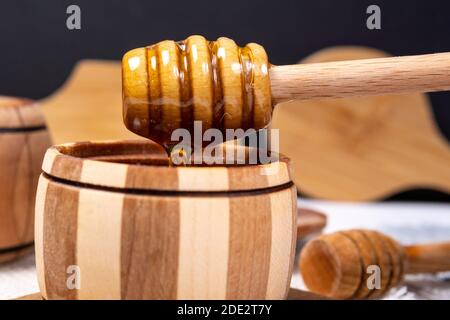 Zuckerpaste oder Schönheitswachs zum Zuckern fließt aus einem Holzdipper. Honig Tropfen aus dem Löffel. Makro-Foto Stockfoto