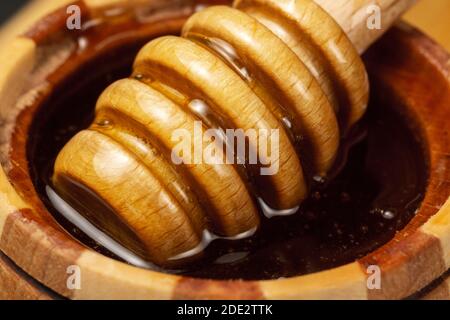 Zuckerpaste oder Schönheitswachs zum Zuckern fließt aus einem Holzdipper. Honig Tropfen aus dem Löffel. Makro-Foto Stockfoto