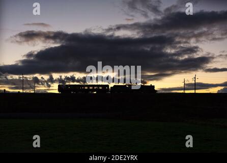 Erhaltene Dampflokomotive 45699 'Galatea' an der Hauptlinie der Westküste Bei Sonnenuntergang Rückkehr nach Carnforth nach dem Arbeiten mit einem Hauptdampfer charterzug Stockfoto