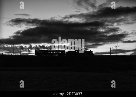 Erhaltene Dampflokomotive 45699 'Galatea' an der Hauptlinie der Westküste Bei Sonnenuntergang Rückkehr nach Carnforth nach dem Arbeiten mit einem Hauptdampfer charterzug Stockfoto