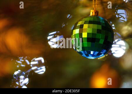 Weihnachtsschmuck. Facettenreiche Kugel im Vordergrund und unscharf im Hintergrund. Stockfoto