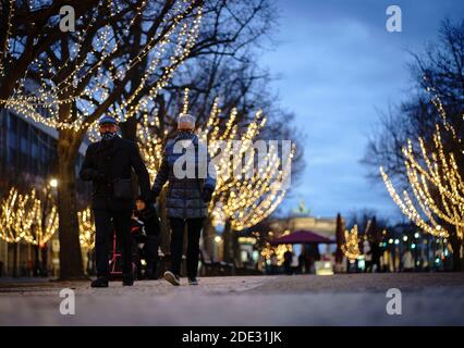 Berlin, Deutschland. November 2020. Passanten mit Mundnasenbezügen spazieren entlang der weihnachtlich beleuchteten Straße 'unter den Linden'. Quelle: Kay Nietfeld/dpa/Alamy Live News Stockfoto