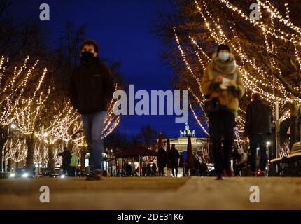 Berlin, Deutschland. November 2020. Passanten mit Mundnasenbezügen spazieren entlang der weihnachtlich beleuchteten Straße 'unter den Linden'. Quelle: Kay Nietfeld/dpa/Alamy Live News Stockfoto