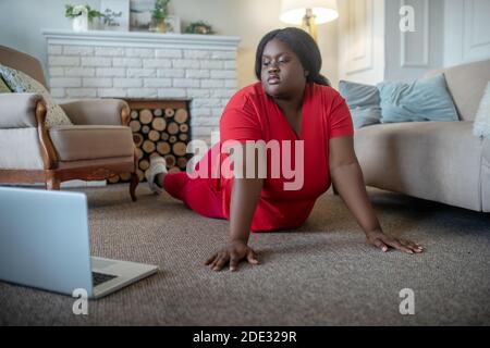 Plus Größe afroamerikanische Frau mit einem Online-Training und In Plank stehend Stockfoto