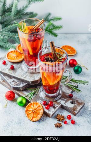 Heißer Tee mit Orangenscheiben und Preiselbeeren in gläsernen Gläsern. Heiße Getränke für Winter und Weihnachten Stockfoto