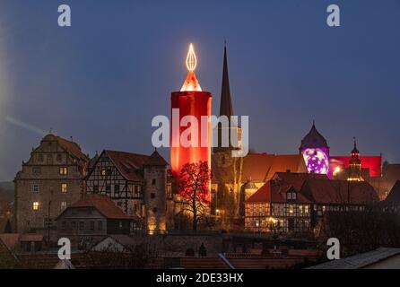 28. November 2020, Hessen, Schlitz: Die "größte Weihnachtskerze" der Welt erstrahlt über dem Städtchen Schlitz. Die Kerze besteht aus einem historischen Steinturm, der in ein rotes Tuch gehüllt ist und an dessen Spitze 110 Glühbirnen montiert sind, um eine sechs Meter hohe "Flamme" zu bilden. Damit erreicht die Kerze eine Gesamthöhe von 42 Metern. Der Weihnachtsmarkt, der normalerweise zur gleichen Zeit stattfindet, wird in diesem Jahr aufgrund der Corona-Pandemie abgesagt. Foto: Boris Roessler/dpa Stockfoto