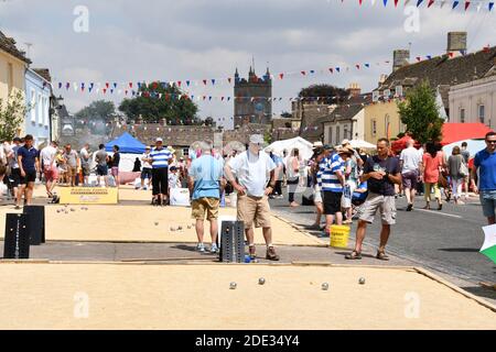 Begeisterte Spieler konzentrieren sich stark auf die International Boules Wettbewerb, eine jährliche Veranstaltung in der breiten High Street von Sherston, Wiltshire, Großbritannien Stockfoto