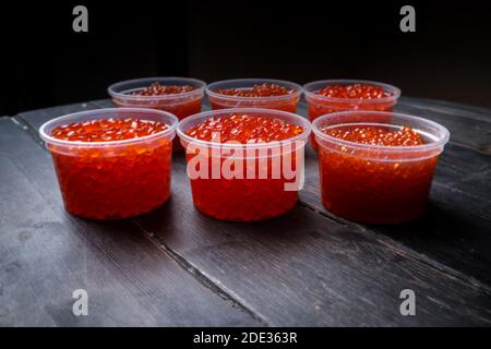 Kaviar mit rosa Lachs und Kaviar mit Chum-Lachs in Plastikbehältern. Meeresfrüchte, Delikatessen, gesunde Ernährung. Stockfoto