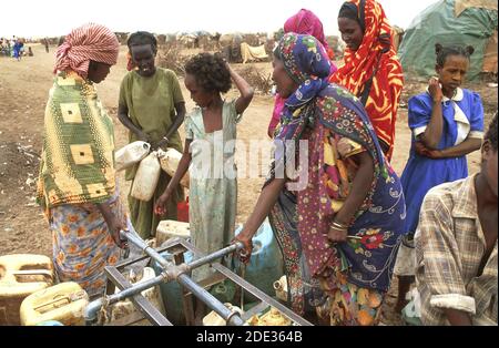 Somalische Flüchtlingsfrauen und Kinder sammeln Wasser aus einem Wasserhahn im Flüchtlingslager. Kebrebeyah, Äthiopien. Stockfoto