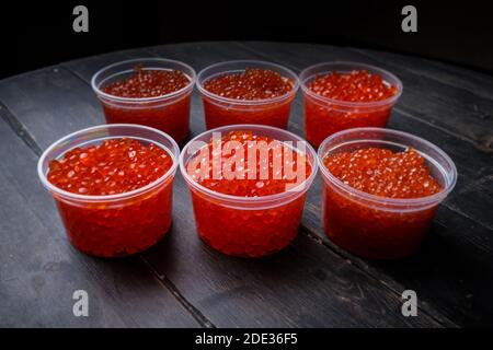 Kaviar mit rosa Lachs und Kaviar mit Chum-Lachs in Plastikbehältern. Meeresfrüchte, Delikatessen, gesunde Ernährung. Stockfoto