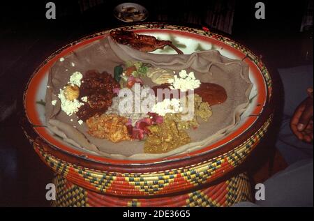 Eine typisch äthiopische Mahlzeit mit Injera und würzigen Füllungen serviert in der traditionellen Weise zu teilen. Addis Abeba, Äthiopien Stockfoto