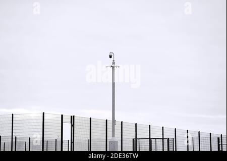 CCTV-Kamera auf Stange über eingezäunten Sportbereich Stockfoto