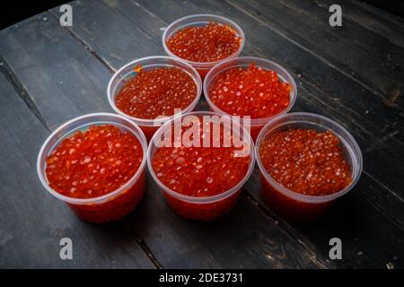 Kaviar mit rosa Lachs und Kaviar mit Chum-Lachs in Plastikbehältern. Meeresfrüchte, Delikatessen, gesunde Ernährung. Stockfoto