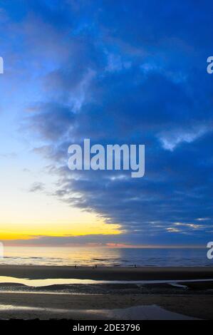 Angeln am Strand bei Sonnenuntergang Stockfoto