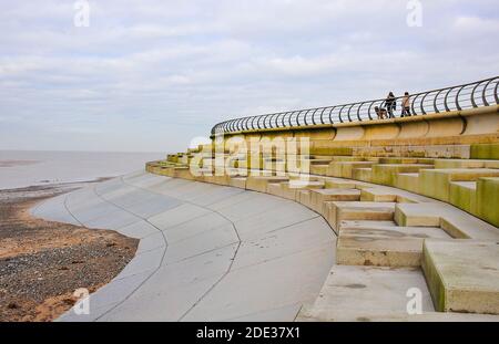 Zwei Personen, die Hunde entlang der Küste von Cleveleys auf einer ruhigen Tag im Winter Stockfoto