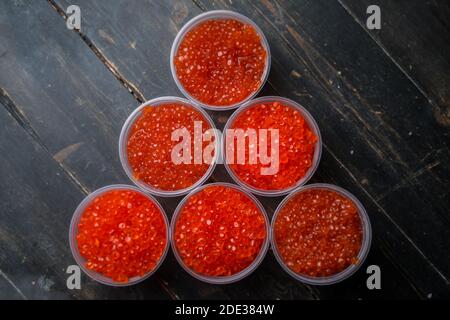 Kaviar mit rosa Lachs und Kaviar mit Chum-Lachs in Plastikbehältern. Meeresfrüchte, Delikatessen, gesunde Ernährung. Stockfoto