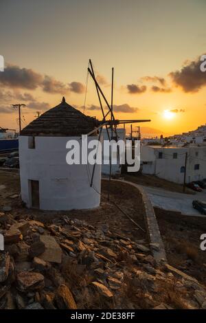 Chora, iOS Insel Griechenland - 21. September 2020: Ikonische, traditionelle Windmühlen auf dem Hauptplatz von Chora. Gelber Sonnenuntergang. Stockfoto