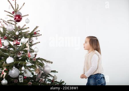 Fascinnated Kleinkind Mädchen suchen nach oben in Richtung Weihnachtsbaum Stockfoto