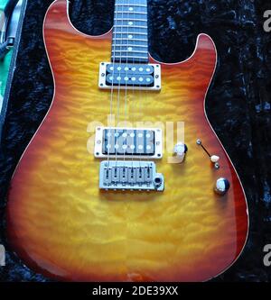 Gesteppte Ahornkirsche auf Mahagoni Palisander E-Gitarre, Kirsche Burst E-Gitarre glühend im Gehäuse. Stockfoto
