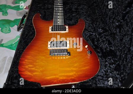 Gesteppte Ahornkirsche auf Mahagoni Palisander E-Gitarre, Kirsche Burst E-Gitarre glühend im Gehäuse. Stockfoto