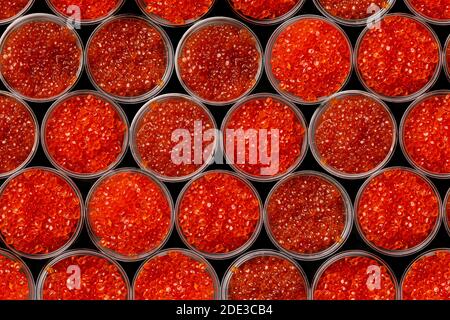 Kaviar mit rosa Lachs und Kaviar mit Chum-Lachs in Plastikbehältern. Meeresfrüchte, Delikatessen, gesunde Ernährung. Draufsicht. Muster von Kaviar. Stockfoto