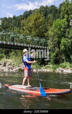 Ein Mann genießt den Fluss auf seinem Stand-up-Paddleboard in Oregon. Stockfoto